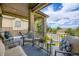 Relaxing covered patio with comfortable seating, a table, and a view of the well-manicured lawn and distant mountains at 11070 Meade Ct, Westminster, CO 80031