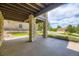 Covered patio with stone pillars and a concrete floor, offering a view of the landscaped yard and surrounding neighborhood at 11070 Meade Ct, Westminster, CO 80031