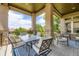 Inviting covered patio featuring a dining table, chairs, and a view of the green landscape beyond the wrought iron railing at 11070 Meade Ct, Westminster, CO 80031