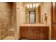 Bathroom featuring a wood vanity and tiled walk-in shower at 28800 Stonecrop Trl, Conifer, CO 80433
