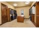 Walk-in closet features custom shelving, storage island, carpeted floors and natural light at 28800 Stonecrop Trl, Conifer, CO 80433