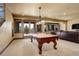Large game room with pool table, comfortable seating, and sliding glass doors to the outside at 28800 Stonecrop Trl, Conifer, CO 80433