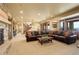 Spacious living room with fireplace, comfortable leather seating, and natural light at 28800 Stonecrop Trl, Conifer, CO 80433