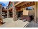 Covered stone patio featuring a hot tub and access to the home's interior at 28800 Stonecrop Trl, Conifer, CO 80433
