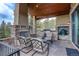 Covered patio with fireplace, built-in grill, and seating area at 28800 Stonecrop Trl, Conifer, CO 80433
