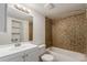Well-lit bathroom with stylish mosaic tile in the shower, a spacious vanity, and ample shelving for storage at 910 S Walden St # 106, Aurora, CO 80017