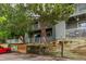 Exterior view of condos showing wooden retaining wall and mature landscaping at 910 S Walden St # 106, Aurora, CO 80017