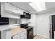 Bright kitchen featuring white cabinets, black appliances, and plenty of storage space for cooking and supplies at 910 S Walden St # 106, Aurora, CO 80017