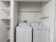 Convenient laundry area equipped with a washer, dryer, and ample shelving for organizing laundry essentials at 910 S Walden St # 106, Aurora, CO 80017