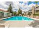 Beautiful community pool with plenty of lounge chairs and a clubhouse in the background at 910 S Walden St # 106, Aurora, CO 80017