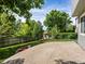 A spacious backyard featuring a concrete patio, lush lawn, mature trees, and a privacy fence at 11578 Clayton St, Thornton, CO 80233