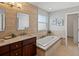 Well-lit bathroom with a soaking tub and double sink vanity at 11578 Clayton St, Thornton, CO 80233