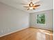 Cozy bedroom with hardwood floors, a ceiling fan, and a bright window with tree view at 11578 Clayton St, Thornton, CO 80233