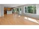Open-concept living area with hardwood floors, large windows, and access to the kitchen and backyard at 11578 Clayton St, Thornton, CO 80233