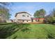 Expansive backyard with a wooden deck, green lawn, and mature trees at 7410 S Dahlia Ct, Centennial, CO 80122