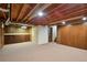 Unfinished basement offers storage with wood paneled wall storage and carpeted floor at 7410 S Dahlia Ct, Centennial, CO 80122