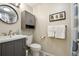 Cozy bathroom featuring a round mirror, a modern vanity, and neutral wall colors at 7410 S Dahlia Ct, Centennial, CO 80122