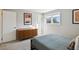 Bright bedroom featuring neutral wall colors, a queen bed, and dresser at 7410 S Dahlia Ct, Centennial, CO 80122