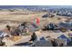 Drone view of a gray house with a three-car garage in a neighborhood near open field at 4695 Bobolink Dr, Castle Rock, CO 80109