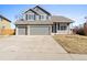 Exterior of a two-story home with a three-car garage, stone accents, and manicured landscaping at 4695 Bobolink Dr, Castle Rock, CO 80109