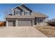 Close up of a charming two-story home featuring a three car garage and stone accents at 4695 Bobolink Dr, Castle Rock, CO 80109