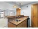 Cozy wet bar with wood cabinets, sink, and mini fridge in finished basement near sliding glass door and outside view at 4695 Bobolink Dr, Castle Rock, CO 80109