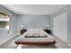 A bedroom is a space where people sleep, furnished with a bed and minimal decor, simple gray walls and hardwood flooring at 33477 Valley View Dr, Evergreen, CO 80439