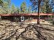 Charming single-story home with wood siding, red roof, and a cozy wooded setting offers privacy and serenity at 33477 Valley View Dr, Evergreen, CO 80439