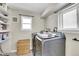 Efficient laundry room with front-loading machines, ample storage, and natural light at 33477 Valley View Dr, Evergreen, CO 80439