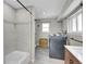 Bright laundry room with white-tiled shower and modern washer and dryer at 33477 Valley View Dr, Evergreen, CO 80439