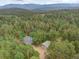 Scenic aerial view of a home with a detached garage, nestled among lush trees at 28858 Richmond Hill Rd, Conifer, CO 80433