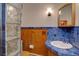 Vintage bathroom featuring blue tile, wood paneling, and ample light at 28858 Richmond Hill Rd, Conifer, CO 80433