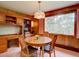 Quaint dining room featuring built-in shelves, wood paneling, and a large picture window at 28858 Richmond Hill Rd, Conifer, CO 80433