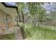 Welcoming front porch with stone accents and wood railing, nestled among lush trees, creates curb appeal at 28858 Richmond Hill Rd, Conifer, CO 80433
