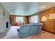 Cozy living room with fireplace, wood paneling, and views of the outdoors at 28858 Richmond Hill Rd, Conifer, CO 80433
