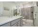 Modern bathroom with gray vanity, quartz countertop, and walk-in shower with glass doors at 9750 Taylor River Cir, Littleton, CO 80125
