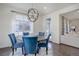 Stylish dining room with blue chairs, chandelier and large windows providing natural light at 9750 Taylor River Cir, Littleton, CO 80125