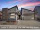 Striking contemporary home with stone accents and a two-car garage, set against a vibrant sunset sky at 9750 Taylor River Cir, Littleton, CO 80125