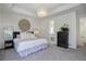 Elegant main bedroom with tray ceiling, chandelier, and doorway to the en suite bathroom at 9750 Taylor River Cir, Littleton, CO 80125