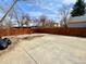 Spacious backyard area with a wooden fence, concrete flooring, and trash bags at 363 Wadsworth Cir, Longmont, CO 80504