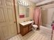 Cozy bathroom featuring a vanity with a wood cabinet, a mirror with vanity lighting, and a shower with pink curtains at 363 Wadsworth Cir, Longmont, CO 80504