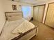 Cozy bedroom featuring natural lighting, a wooden bed, neutral colored decor, and a sliding closet door at 363 Wadsworth Cir, Longmont, CO 80504