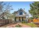 Charming two-story home features a covered porch, brick walkway, and meticulously landscaped front yard at 347 Bannock St, Denver, CO 80223