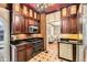 Modern kitchen with stainless steel appliances, dark wood cabinetry, and an exposed brick wall at 347 Bannock St, Denver, CO 80223