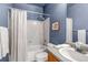 Cozy bathroom with blue walls, bathtub and shower combination with white curtain and towels, and vanity sink at 18384 E Bethany Pl, Aurora, CO 80013