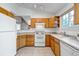 Well-lit kitchen features wood cabinets, white appliances, and a view to the adjacent living area at 18384 E Bethany Pl, Aurora, CO 80013
