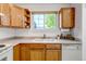 Charming kitchen featuring light wood cabinetry, double sink, and a large window offering natural light at 18384 E Bethany Pl, Aurora, CO 80013