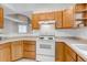 Efficient kitchen featuring wood cabinets, white appliances, and ample counter space for all your cooking needs at 18384 E Bethany Pl, Aurora, CO 80013