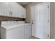Efficient laundry room features modern appliances, cabinet storage, and a convenient entrance to the home at 18384 E Bethany Pl, Aurora, CO 80013