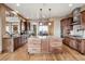 Gourmet kitchen with stainless steel appliances, a large center island, custom cabinets, and hardwood floors at 5261 Sedona Dr, Parker, CO 80134